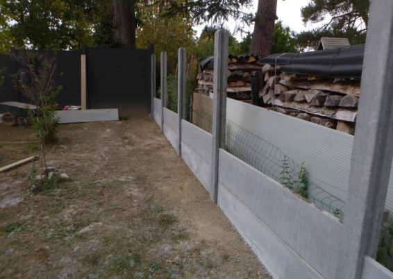 Placement de palissades en plaques de bétons.