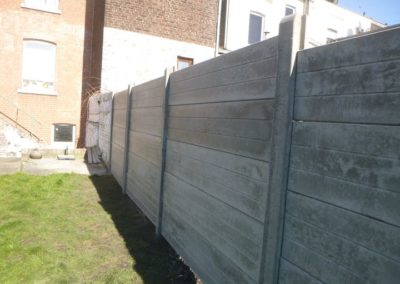 Implantation d'une palissade en plaques de béton imprimée entre deux petits jardins à Angleur....