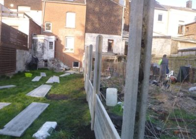 Implantation d'une palissade en plaques de béton imprimée entre deux petits jardins à Angleur....