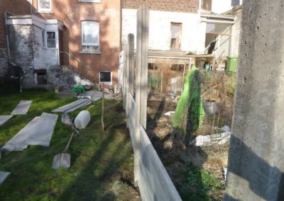 Implantation d'une palissade en plaques de béton imprimée entre deux petits jardins à Angleur....