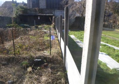 Implantation d'une palissade en plaques de béton imprimée entre deux petits jardins à Angleur....