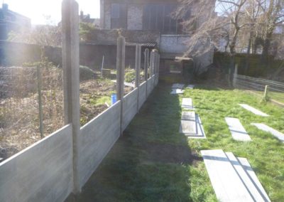 Implantation d'une palissade en plaques de béton imprimée entre deux petits jardins à Angleur....