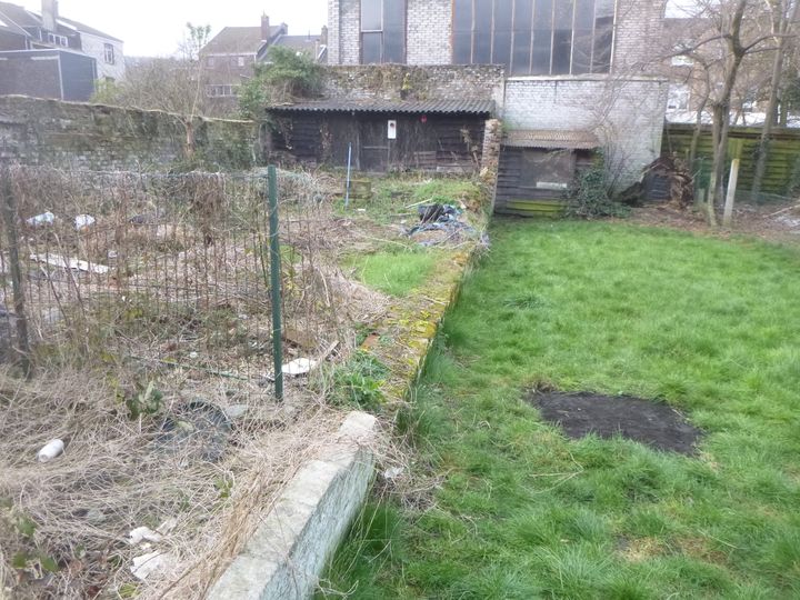 Implantation d'une palissade en plaques de béton imprimée entre deux petits jardins à Angleur....
