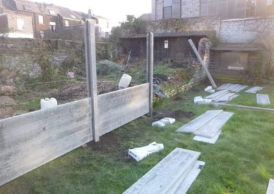 Implantation d'une palissade en plaques de béton imprimée entre deux petits jardins à Angleur....