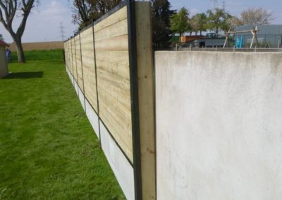 Placement de palissades composées de piquets de métal, soubassement de béton et planches traitée...