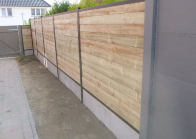 Placement de palissades composées de piquets de métal, soubassement de béton et planches traitée...