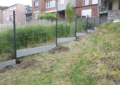 Installation d'une clôture rigide avec soubassement de béton, autour d'un jardin à Herstal.

L'ac...