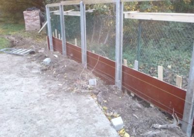 Construction d'un mur de soutien surplombé d'une palissade de béton structuré et placement d'une ...