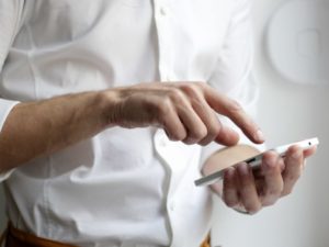 person holding white Android smartphone in white shirt