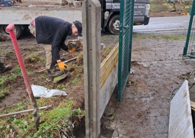 Petite installation d'une palissade composées de piquets de bétons avec soubassement de béton et ...