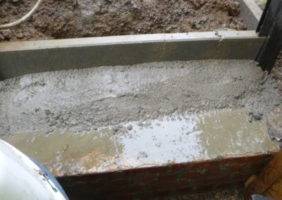 Installation d'une palissade en composite avec une bordure de béton de retenue de terre dans le pie...