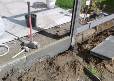 Installation d'une palissade en composite avec une bordure de béton de retenue de terre dans le pie...