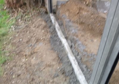 Installation d'une palissade en composite avec une bordure de béton de retenue de terre dans le pie...