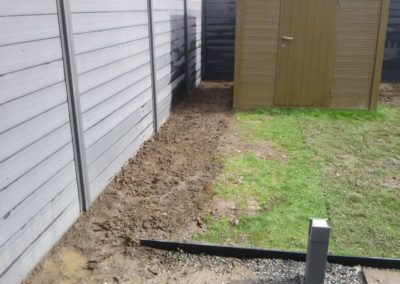 Installation d'une palissade en composite avec une bordure de béton de retenue de terre dans le pie...