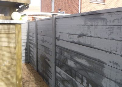 Installation d'une palissade en composite avec une bordure de béton de retenue de terre dans le pie...