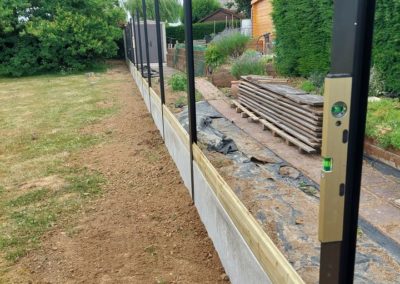 Remplacement d'une clôture en bois par une palissade composée de piquets de métal, soubassement d...