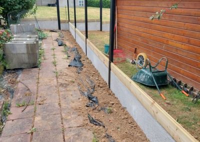 Remplacement d'une clôture en bois par une palissade composée de piquets de métal, soubassement d...