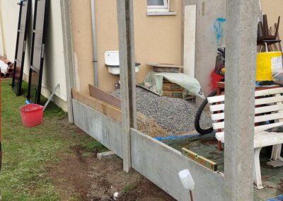 Remplacement d'une haie de ligustrum malade par un palissade composée de piquets de béton et de la...